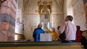 Menschen schauen in einer Kirche die Bilder an unter Anleitung von Hans Peetz.