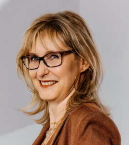 Referentin mit Seitenfoto: Brille, blonde halblange Haare.