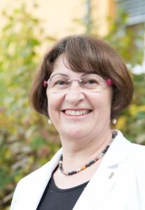 Porträtfoto von Tanzleiterin Erika Richter: Frau mit Brille, braunen halblangen Haaren.