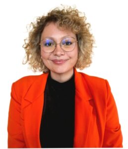 Referentin Jessica Späth: Locken, Brille, rotes Jackett.