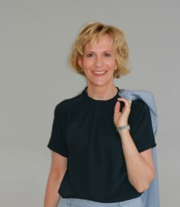 Blonde Frau, die lacht und ein schwarzes kurzärmeliges T-Shirt anhat
