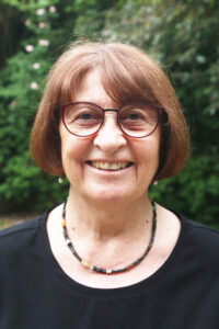 Referentin Erika Richter: braune Haare, Brille, grüner Hintergrund